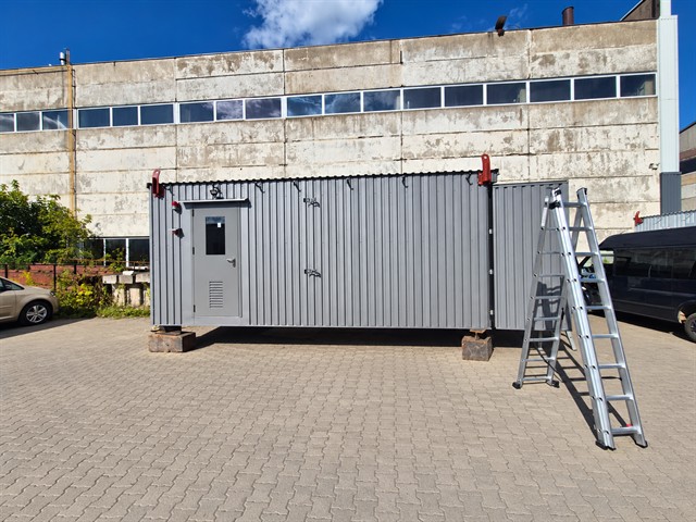 Pilkas konteineris su skardos apdaila iš priekio